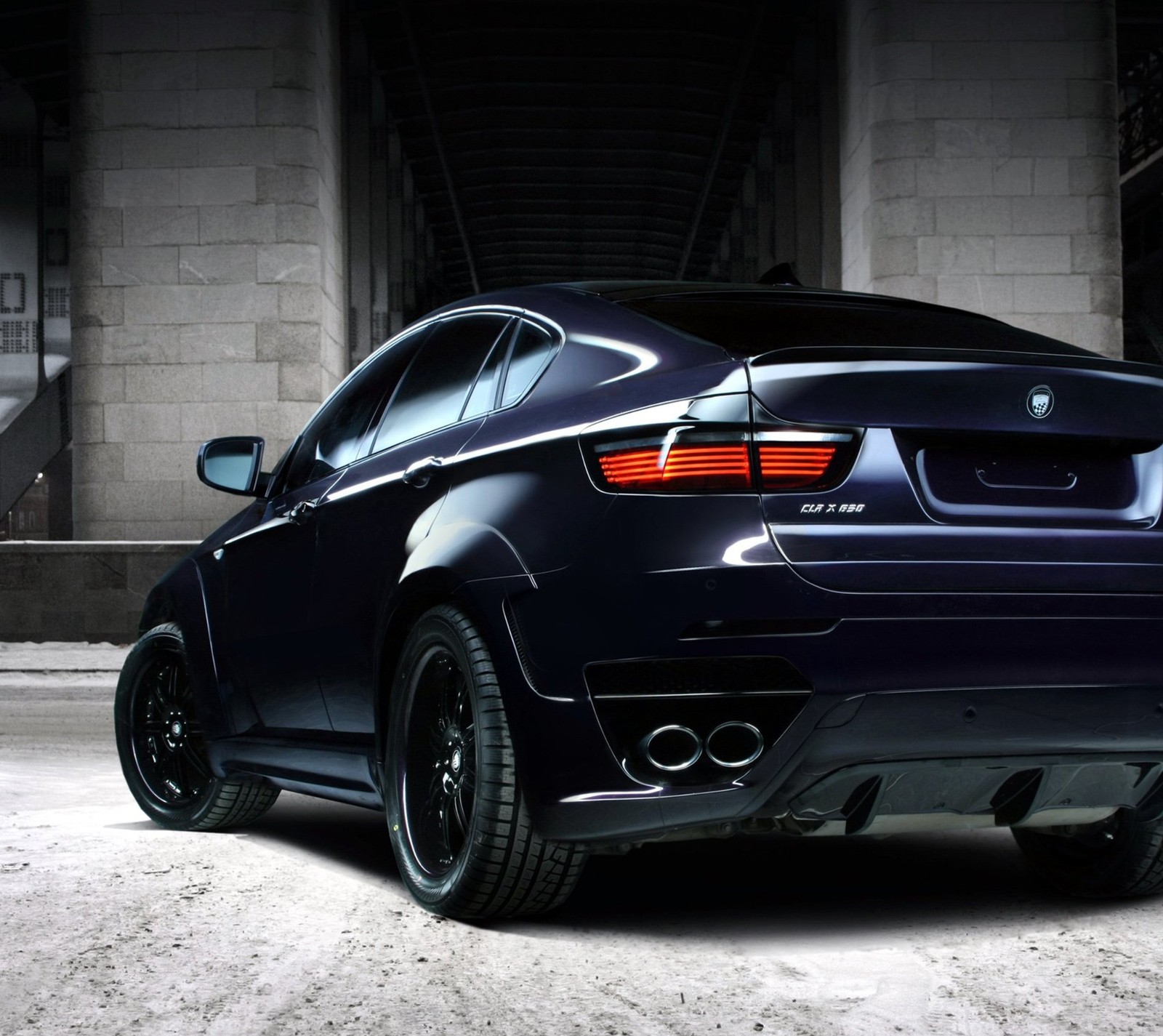 A close up of a black car parked in a parking garage (bmw, car, tuned, x6)