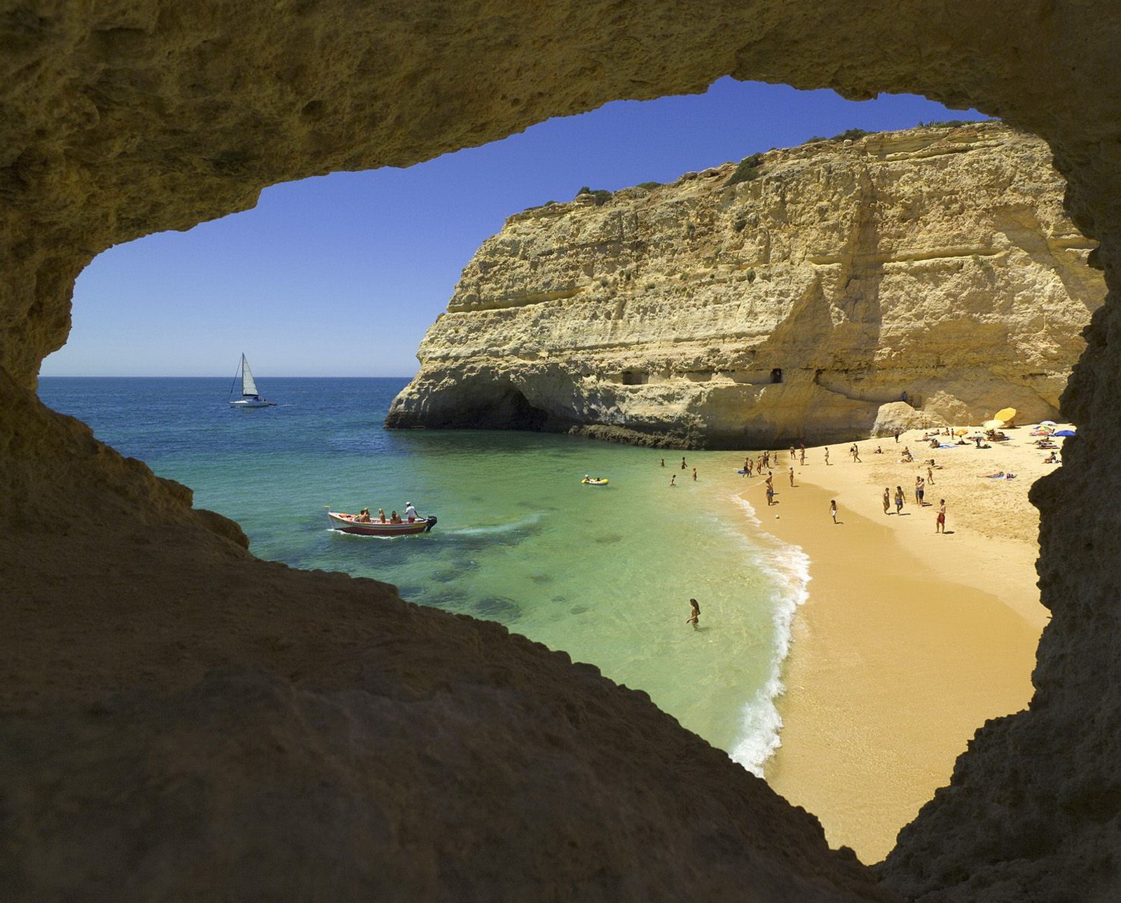 Luftaufnahme eines strandes mit einem boot und menschen darauf (algarve, beach near carvoeiro, portugal)