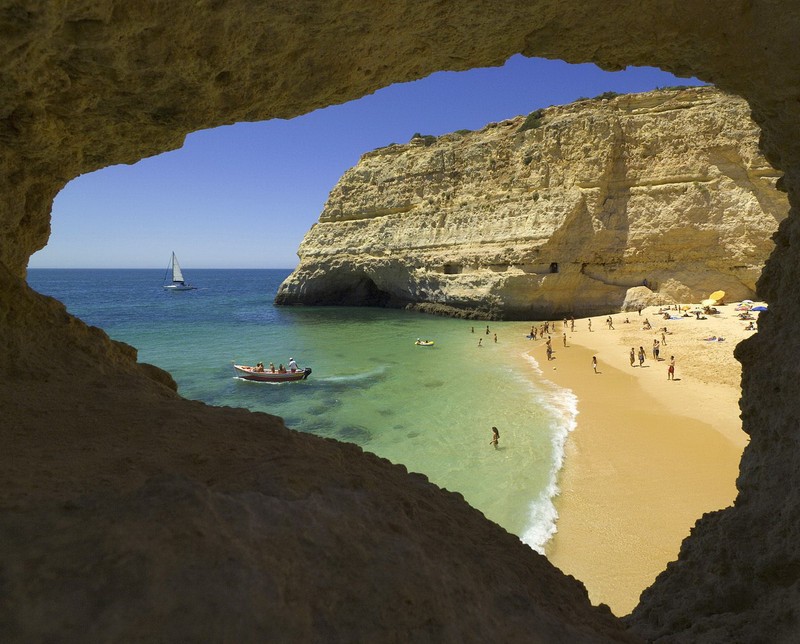 Аэрофотоснимок пляжа с лодкой и людьми на нем (algarve, beach near carvoeiro, португалия)