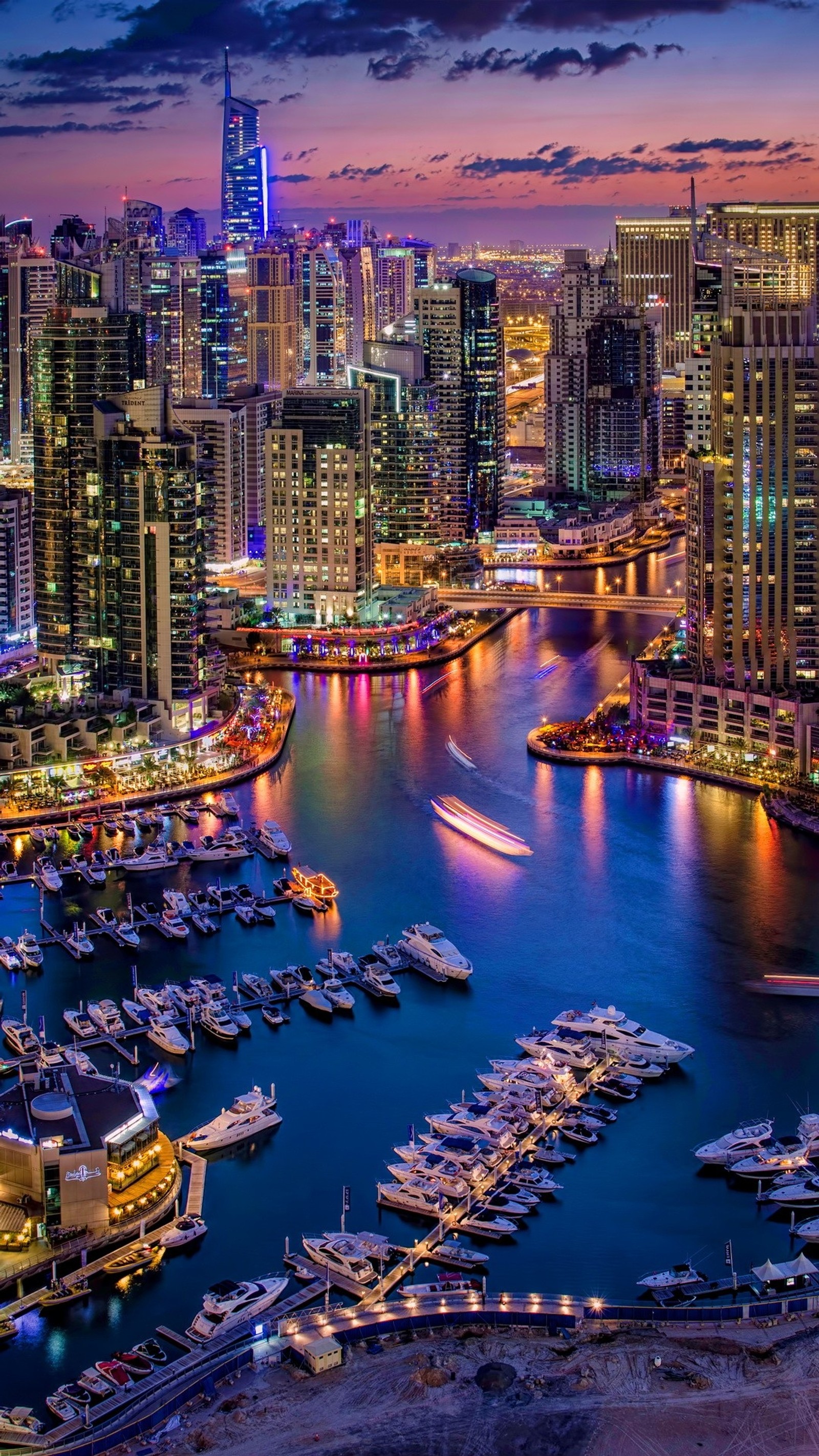 Vista aérea de uma cidade à noite com barcos no porto. (marina de dubai, turismo, água, edifício, arranha céus)