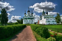 Historic Monastery Surrounded by Lush Greenery Under a Dramatic Sky