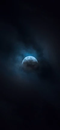 Vollmond leuchtet durch dunkle Wolken in einem Mitternachts Himmel