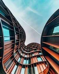 Innovative Skyscraper Facade with Curved Architecture Against a Blue Sky