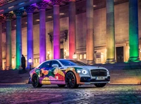 2021 Bentley Flying Spur: Un vibrante coche de arte exhibido contra un fondo histórico