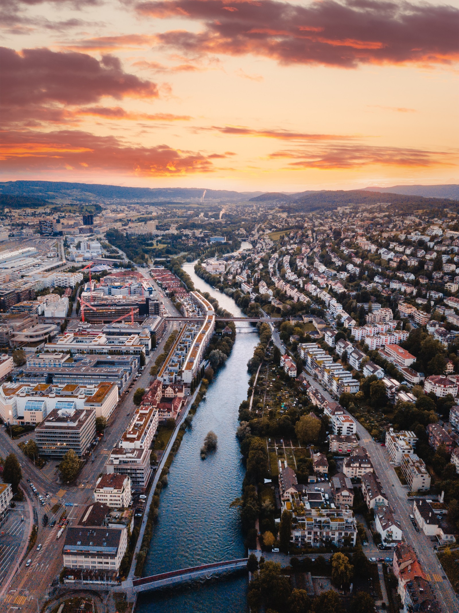 Aerial view of a city with a river and a bridge (sky, waterway, urban area, cityscape, water)