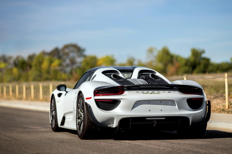 Белый спортивный автомобиль едет по дороге рядом с лесом (porsche 918 spyder, porsche, машина, суперкар, спортивный автомобиль)