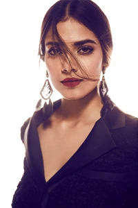 Retrato elegante de Malavika Mohanan, uma proeminente atriz indiana, com maquiagem marcante e um traje estiloso, capturado com um fundo suave e etéreo.