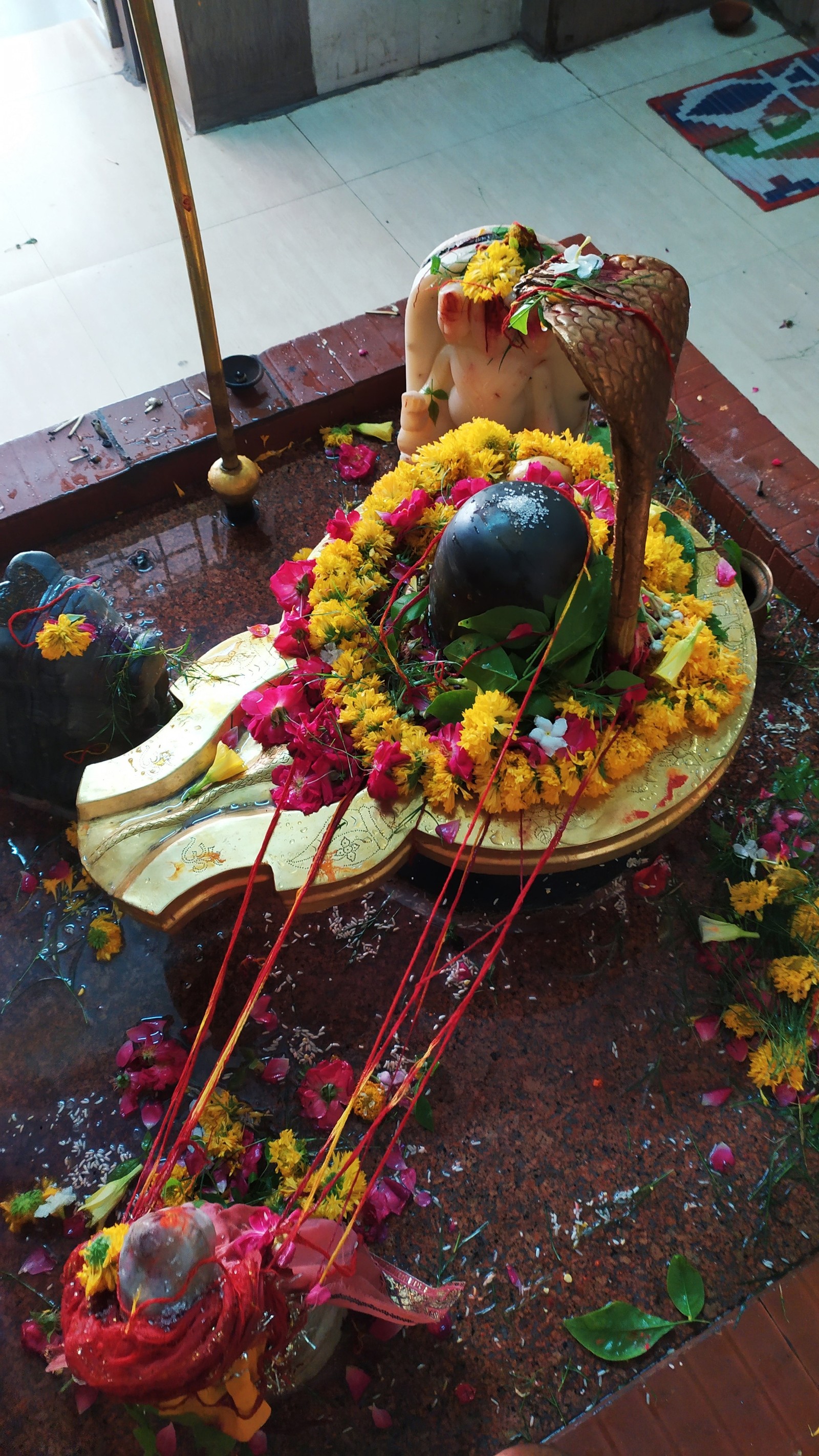 Hay una estatua de una vaca con flores sobre ella (bholenath, mahakaal, shiv)