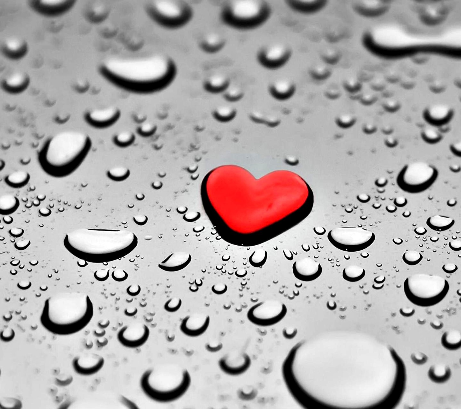 A close up of a red heart on a wet surface (symbol love)