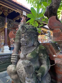 Steinmetzarbeit einer Wächterstatue in einem balinesischen Tempel