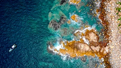 Vista aérea de una playa rocosa con un bote en Hong Kong