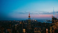 Étonnante skyline de New York à la tombée de la nuit : Gratte-ciels emblématiques illuminés