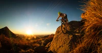 Ciclista de montaña navegando por terreno rocoso al atardecer