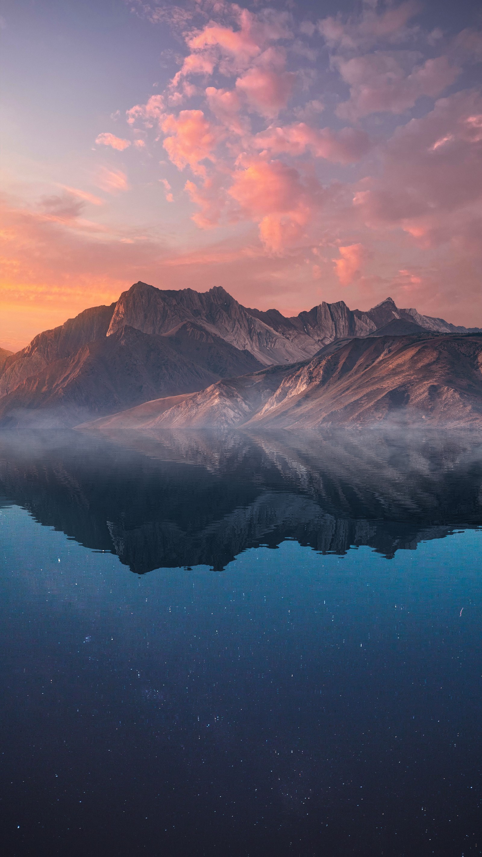 Montanhas refletidas em um lago ao pôr do sol com um céu rosa (natureza, paisagem, nuvem, água, recursos hídricos)