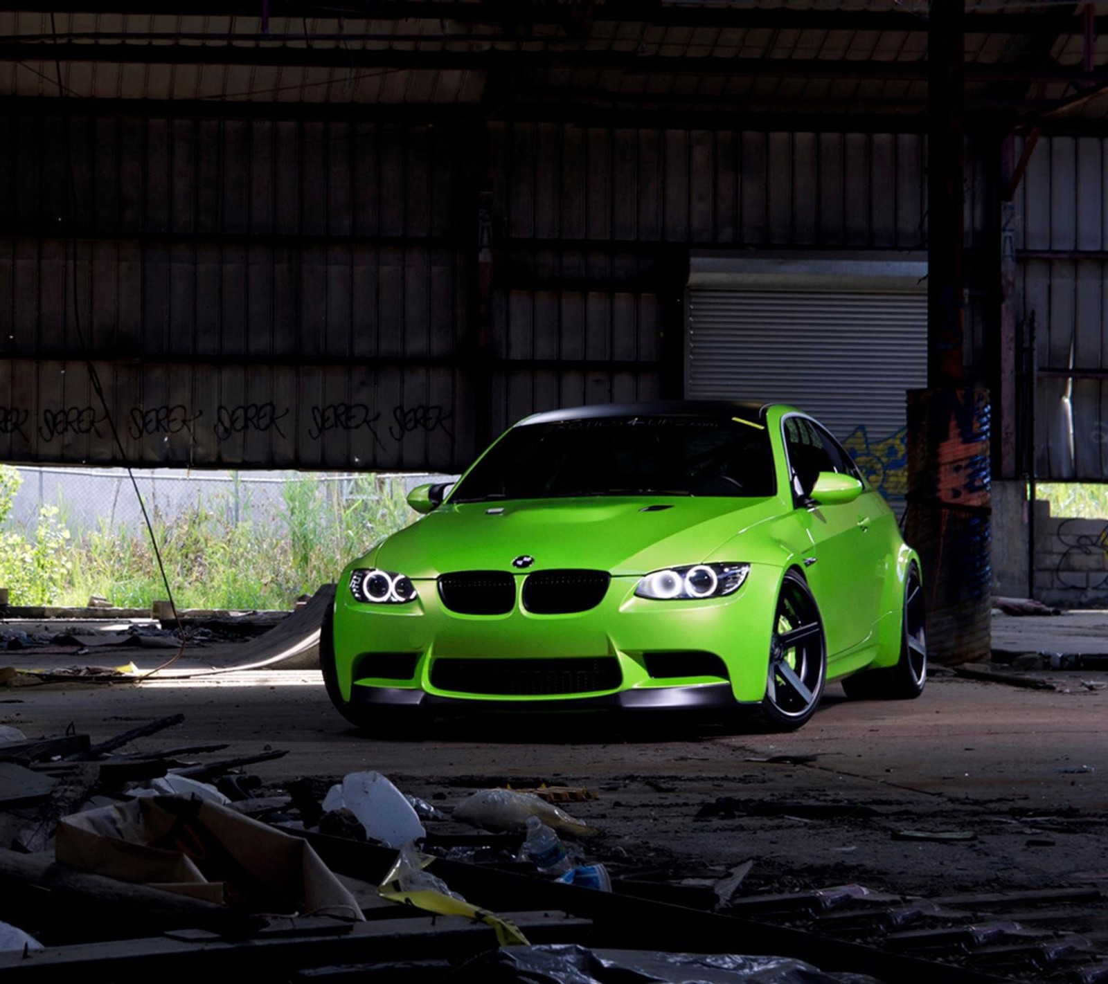 A close up of a green car parked in a garage (bmw, green)