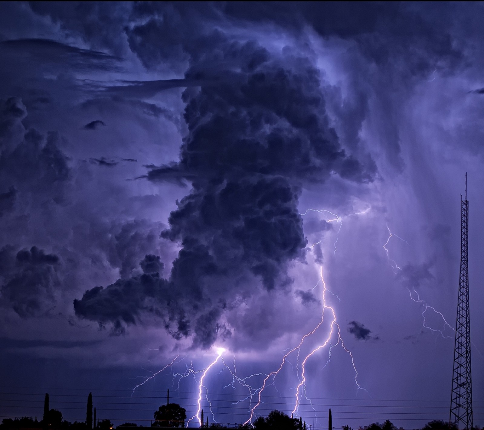 Lightning strikes through a dark sky with a tower in the background (blue, hd, light, nature, sky)