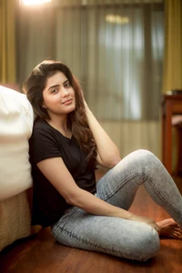 Amritha Aiyer in a casual pose, showcasing a relaxed style in a cozy setting.