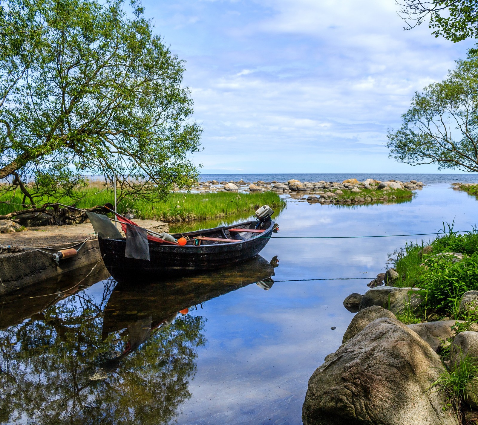 Ein boot sitzt im wasser nahe dem ufer (boot, fluss, steine, schweden, bäume)