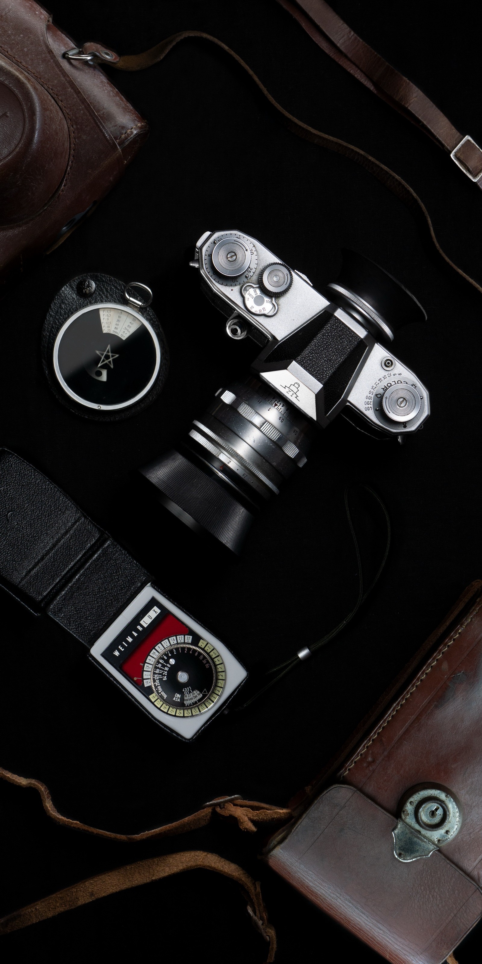 A close up of a camera, a camera case, and a camera (cars, lomography, hood, camera lens, automotive lighting)