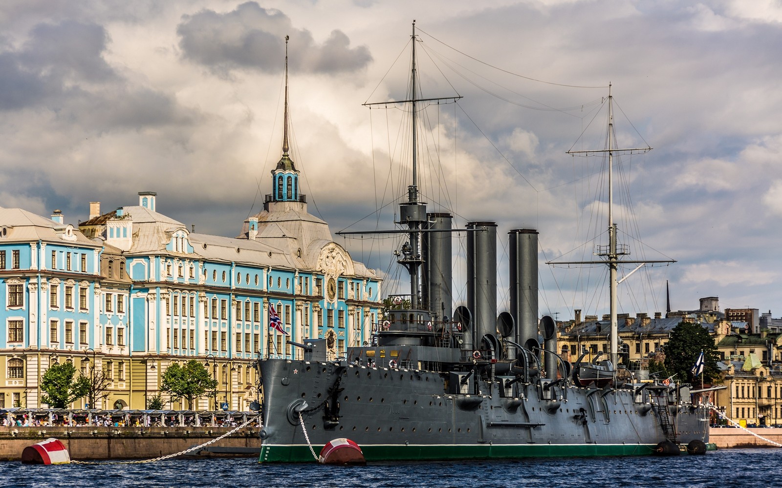 Arafed ship in the water near a city with a building in the background (ship, watercraft, warship, cruiser, battleship)