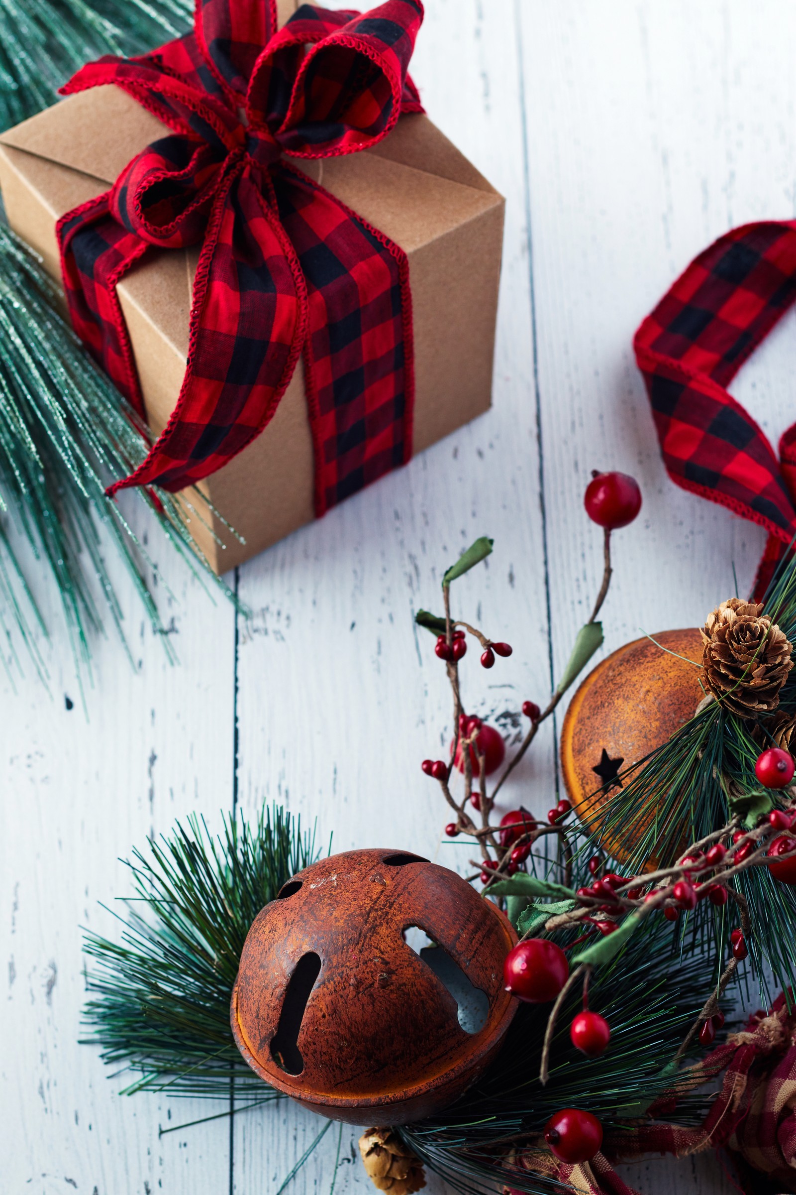 Auf einem tisch liegt eine kleine glocke und eine schachtel mit einer schleife (weihnachtstag, rot, weihnachten, weihnachtsornament, geschenkverpackung)