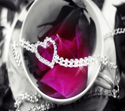 Pulsera de diamantes en forma de corazón sobre pétalos de rosa