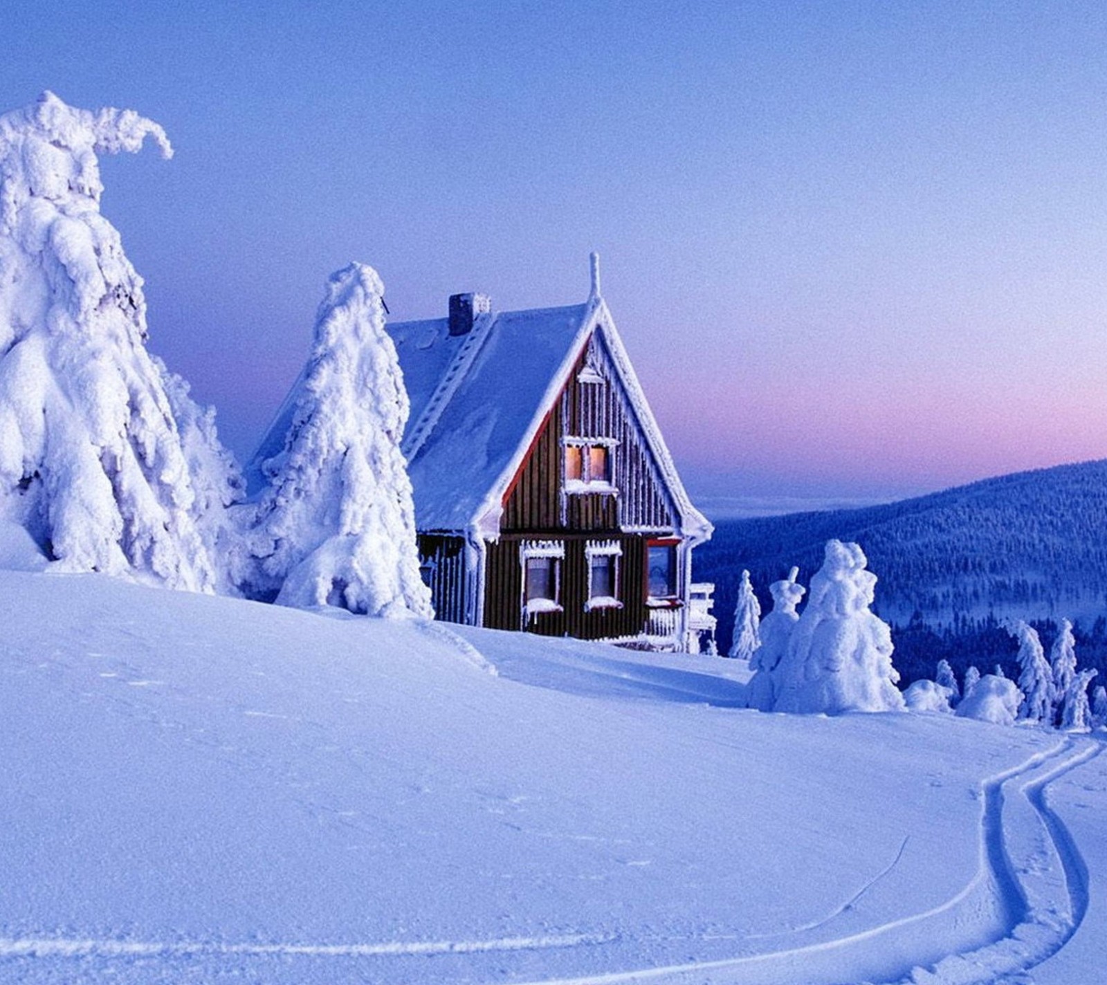 Un chalet enneigé dans les montagnes avec des traces dans la neige (frozen, maison, montagne, neige, hiver)