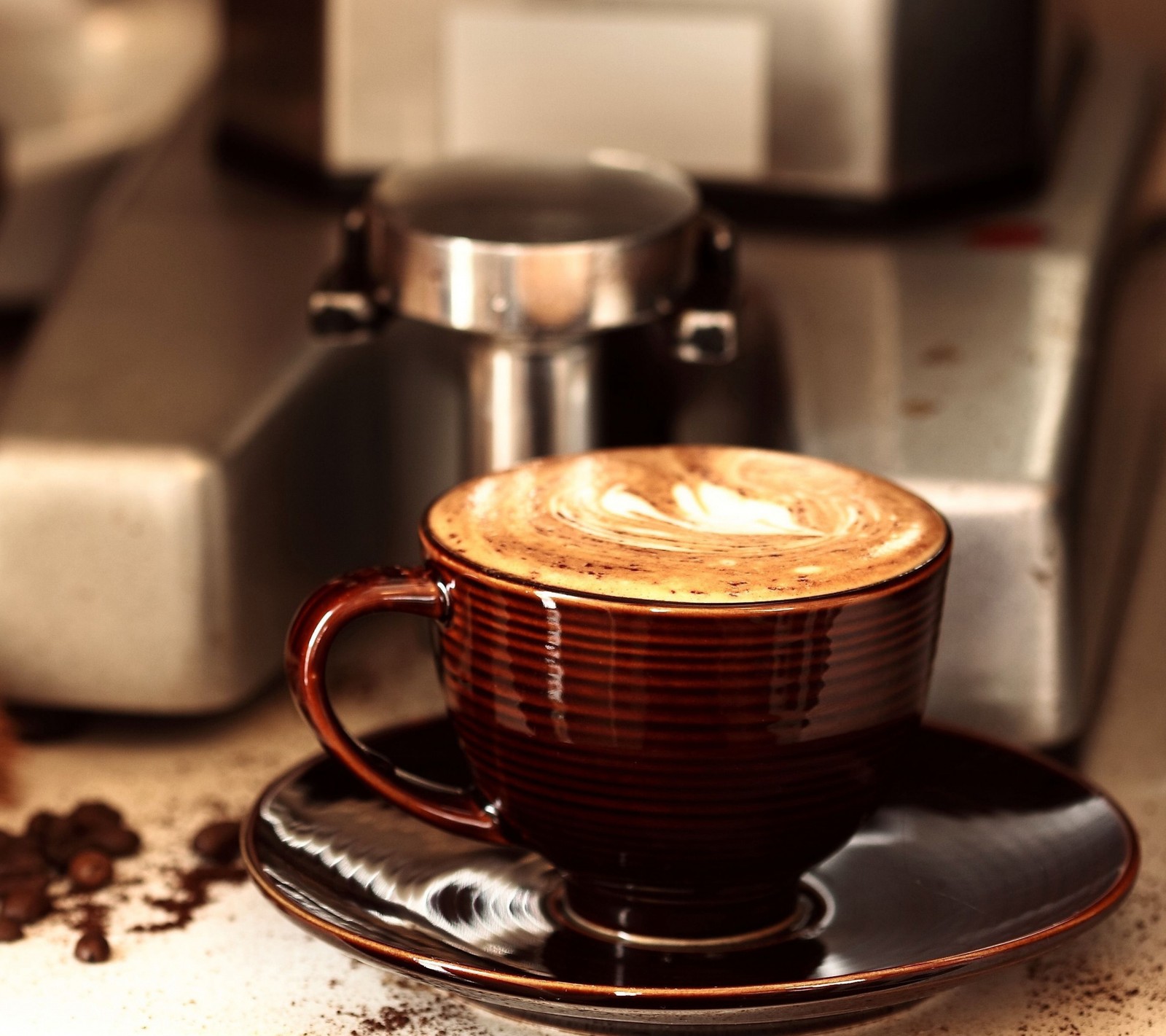 Hay una taza de café en un plato sobre una mesa (cappuccino, café)