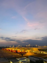 Céus da noite sobre o aeroporto com aeronaves ao crepúsculo