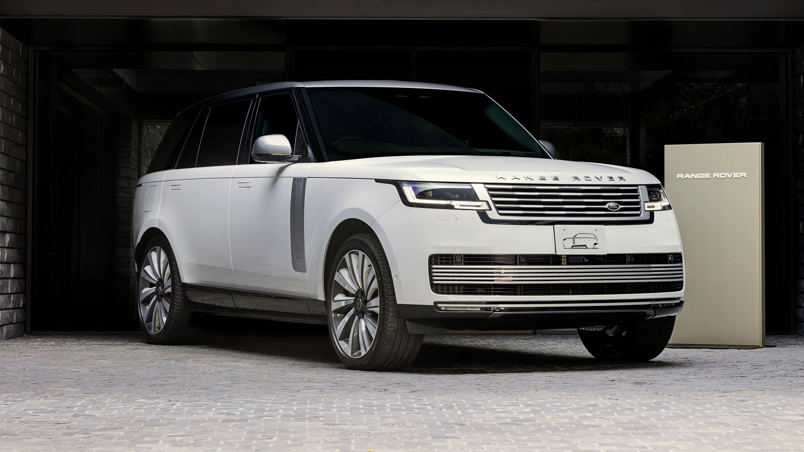 A white range rover parked in front of a garage (range rover sv, bespoke, 5k, 8k, 2024)