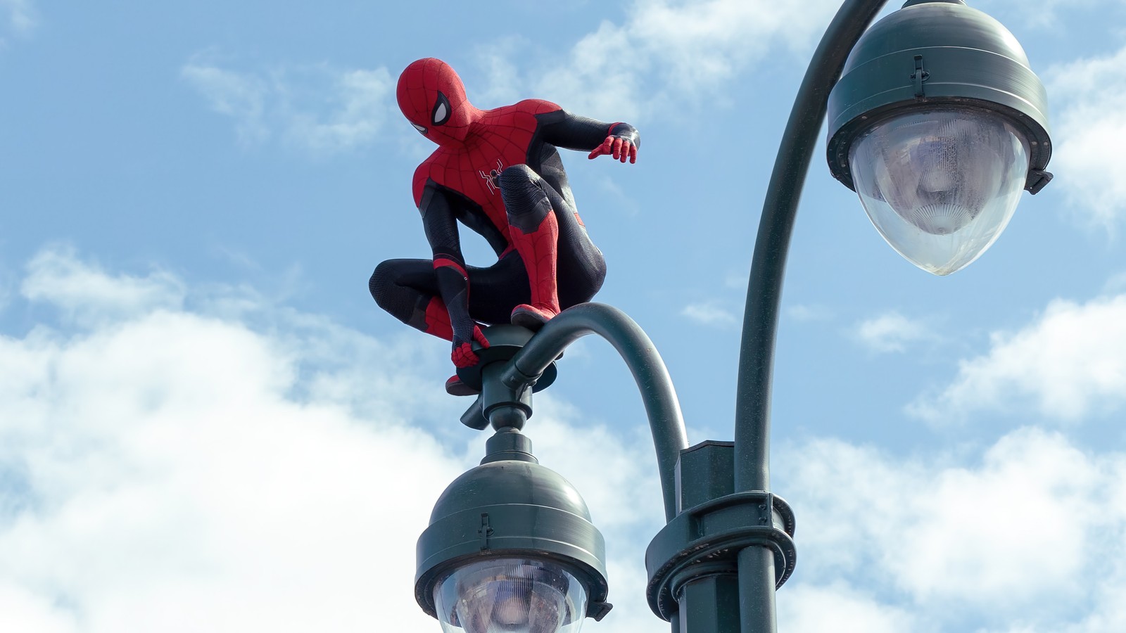 Homme araignée sur un lampadaire avec un ciel nuageux en arrière-plan (spider man pas de chemin à la maison, spider man no way home, film, 2021, spiderman)