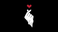 Finger Heart Gesture with Red Heart on Black Background