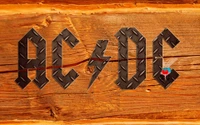 AC/DC-Logo auf einem gefärbten Holz-Hintergrund