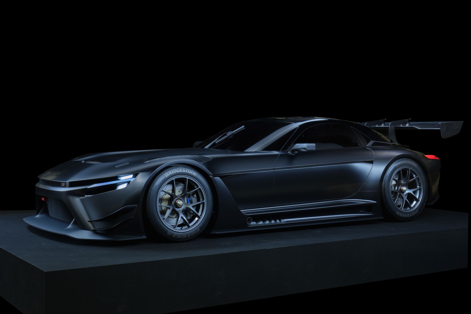 Un primer plano de un coche deportivo negro en una plataforma negra (toyota gr gt3 concepto, coches deportivos, estética oscura, 2022, fondo negro)