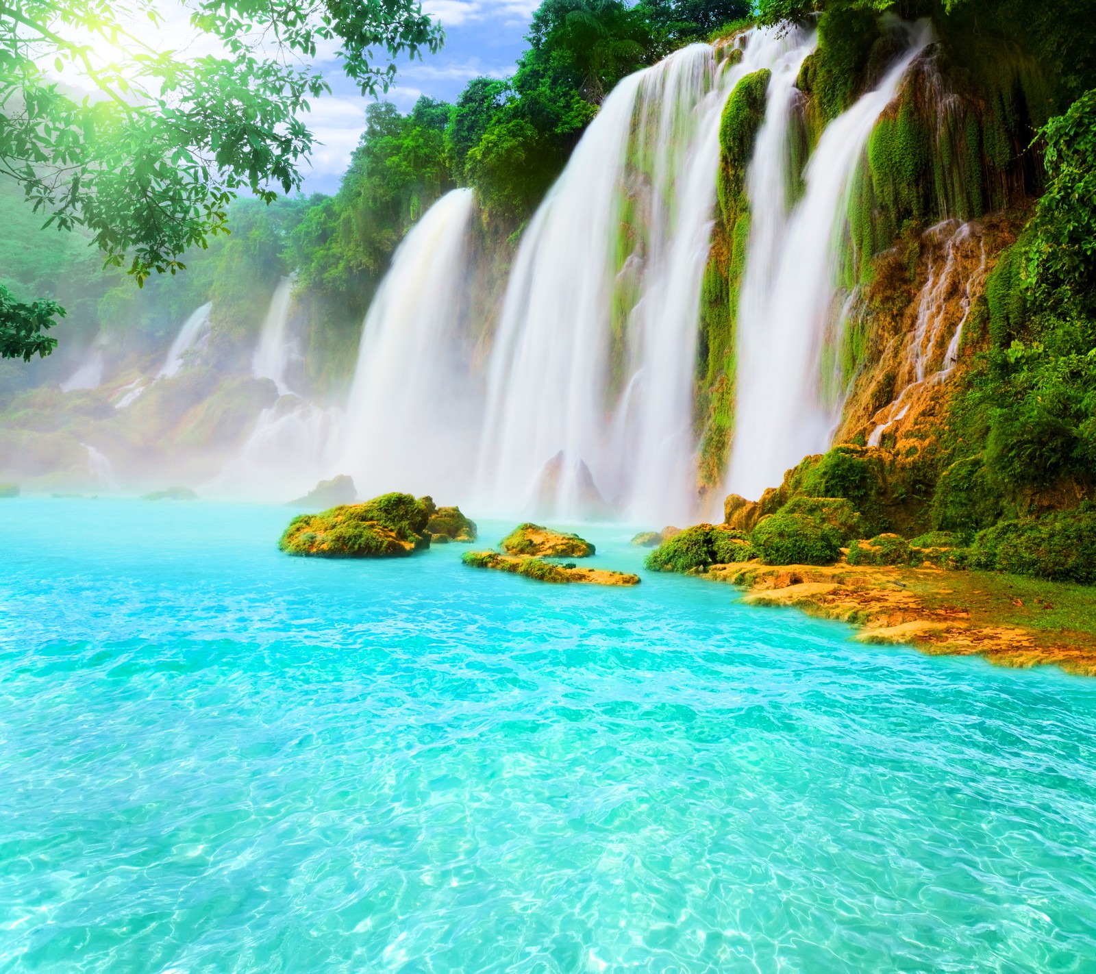 Une cascade au milieu d'un lac bleu entouré d'arbres (beau, nature, tropical, la cascade)