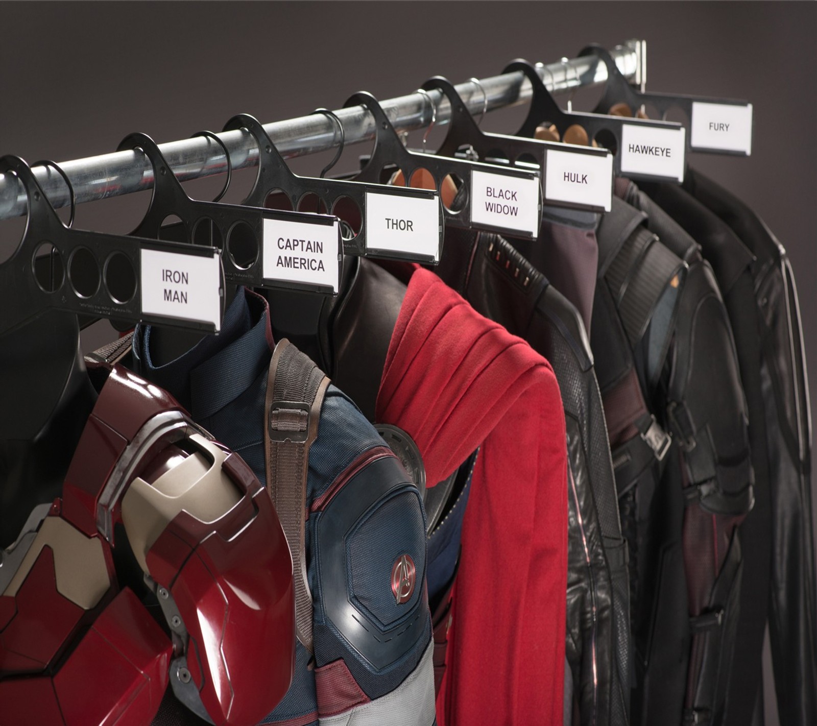 There are many different types of jackets hanging on a rack (cartoon, comics, dc, drawn, hollywood)