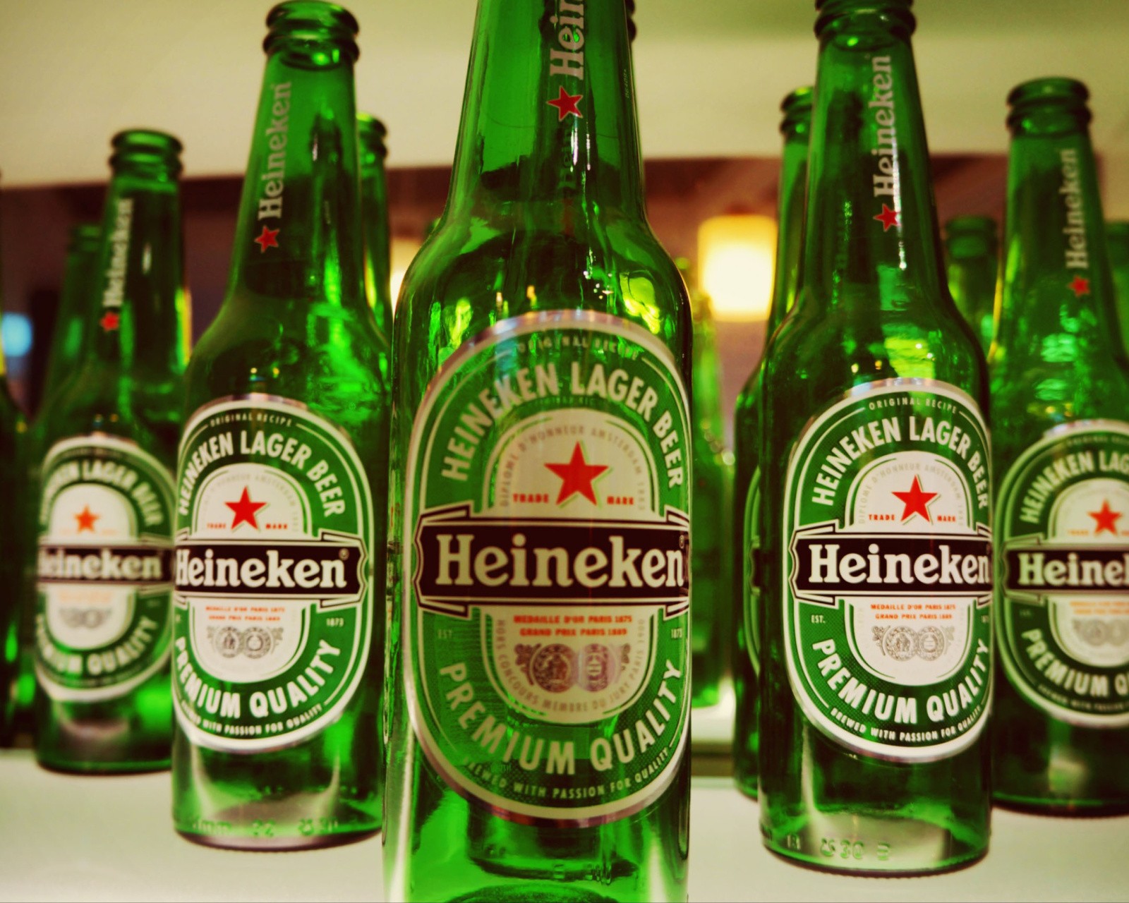 Botellas de cerveza heineken alineadas en un mostrador (cerveza, genial)