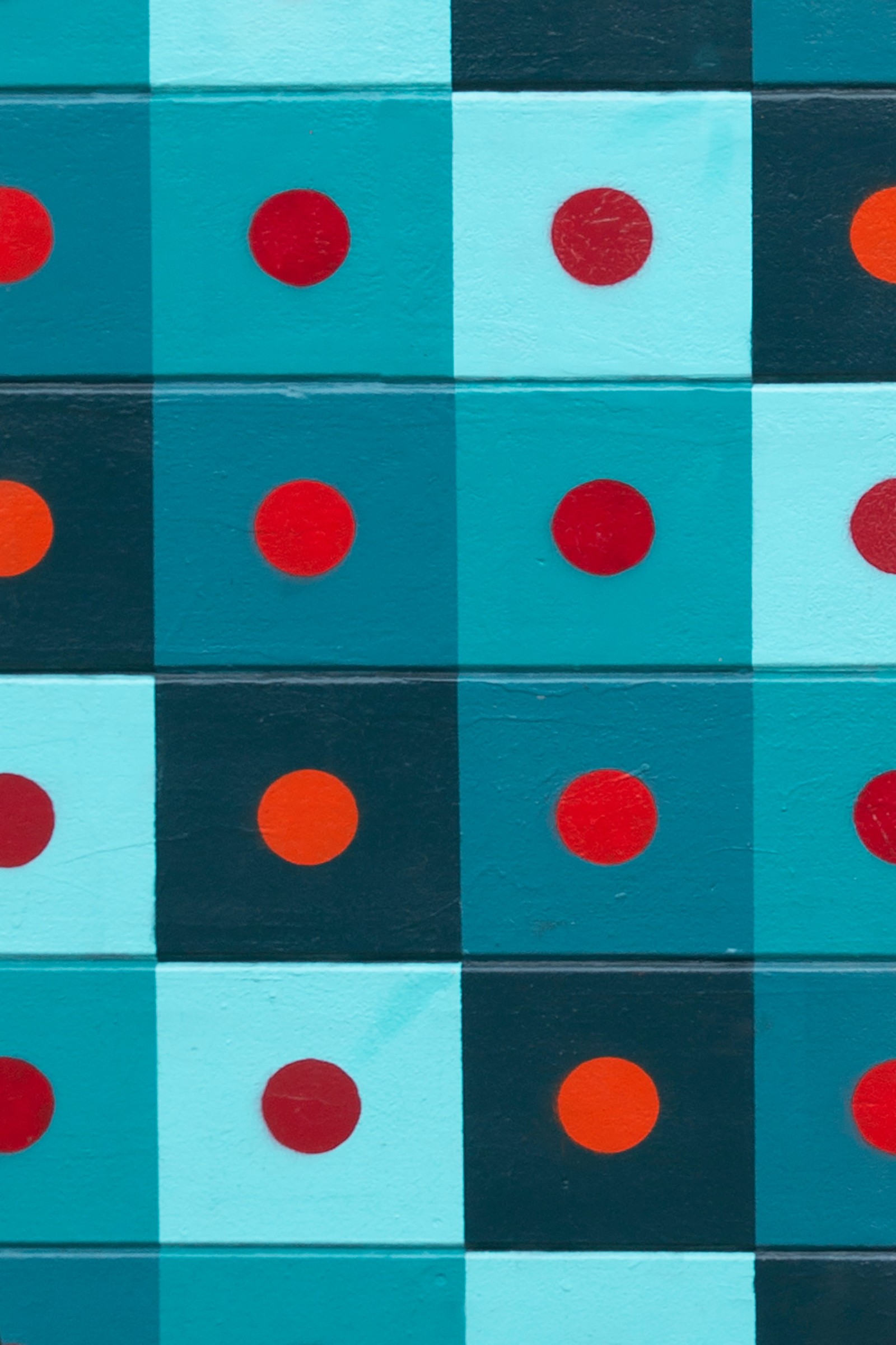 Un gros plan d'un mur peint coloré avec des points rouges et bleus (motif, turquoise, design, coloré, cercle)