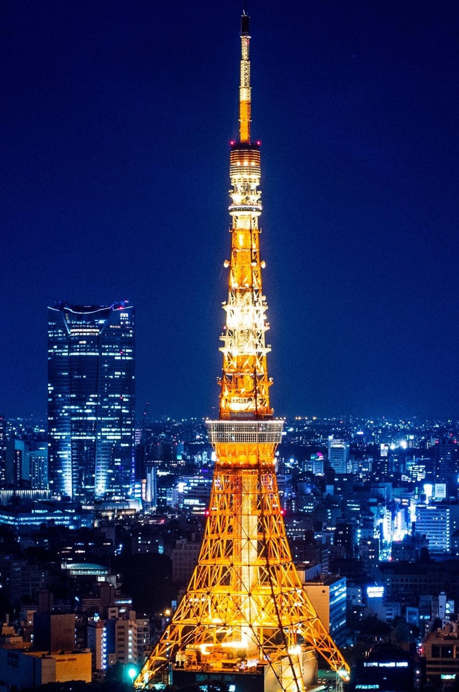 Vista aérea de uma cidade à noite com uma torre alta (paris, torre)