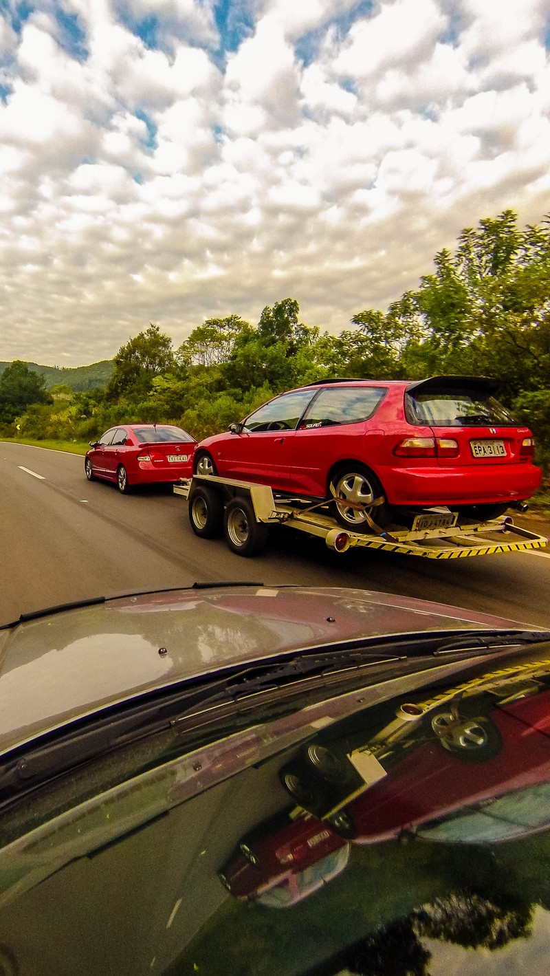 There are two cars on the road being towed by a tow truck (car, civic, honda, japan, road)