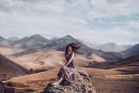 Abrazando la serenidad: una mujer en un paisaje montañoso de ensueño