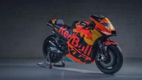 Moto KTM MotoGP com marca Red Bull em ambiente de estúdio