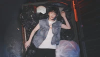 Soobin de Tomorrow X Together dans une pose frappante au milieu d'un décor de sacs poubelles, incarnant des thèmes de rébellion et d'introspection.