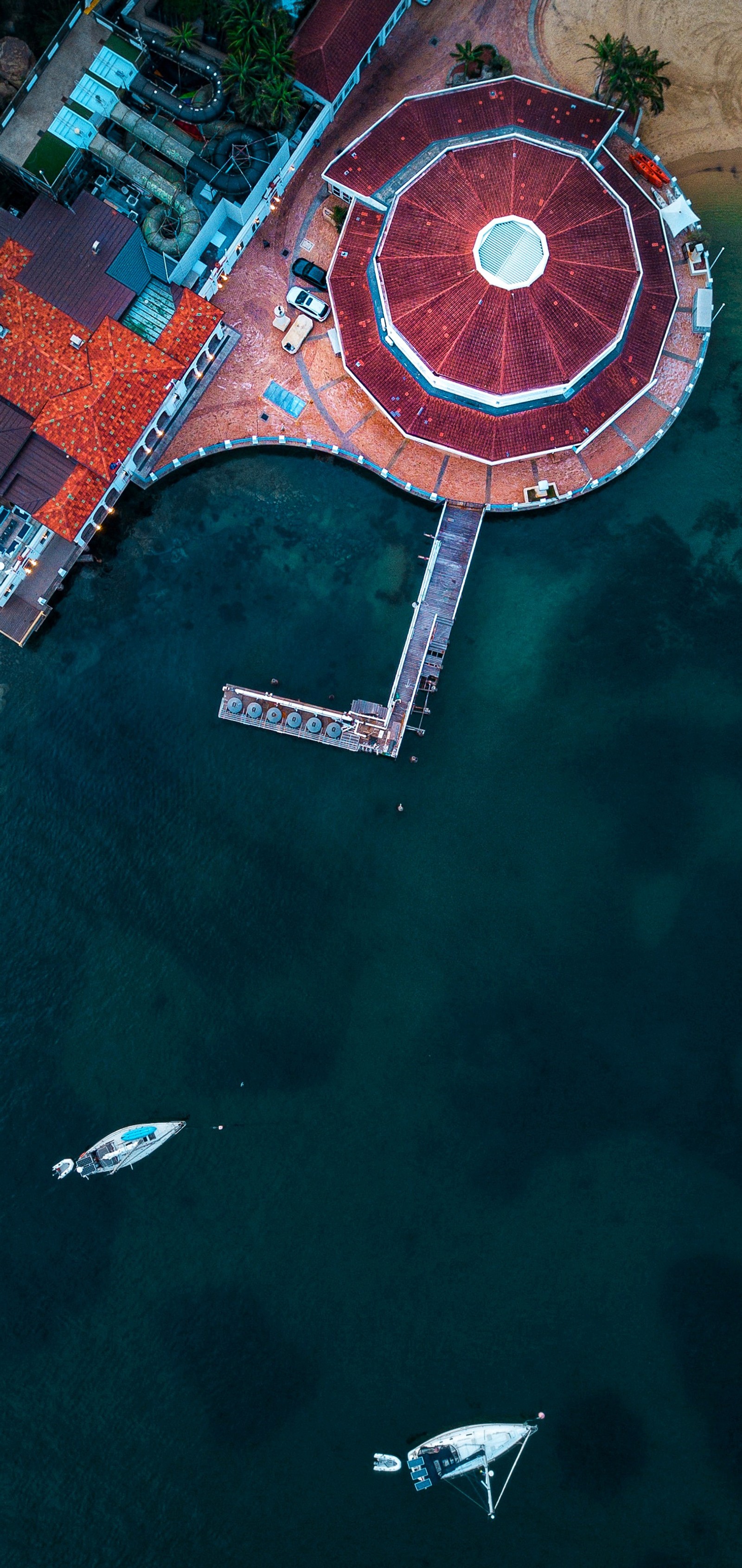 Vista aérea de um cais com um barco e um barco na água (reflexo, água, paisagem, asfalto, recreação)