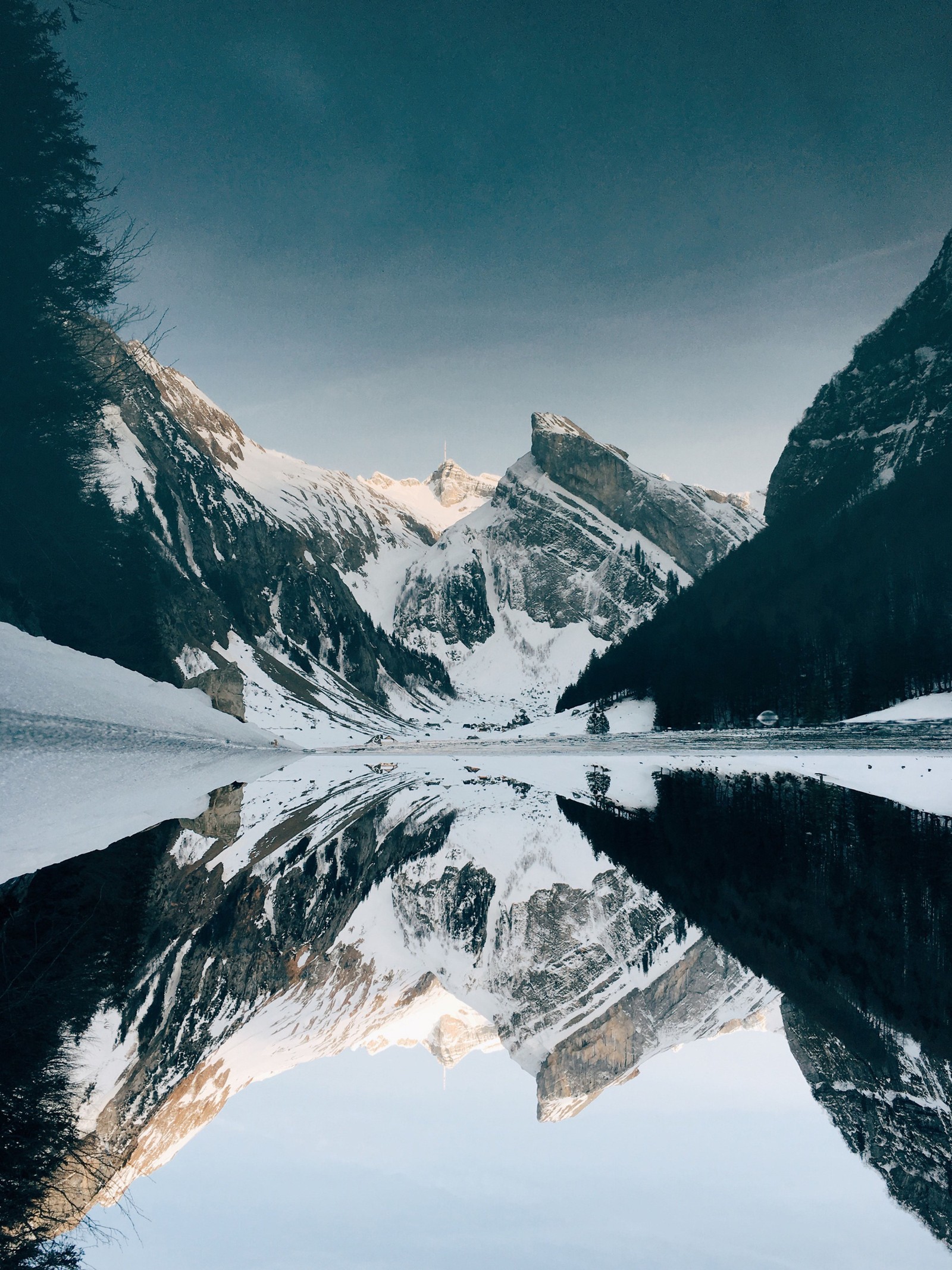 Montagnes reflétées dans un lac avec de la neige au sol (montagne, neige, montagnes enneigées, chaîne de montagnes, formes montagneuses)