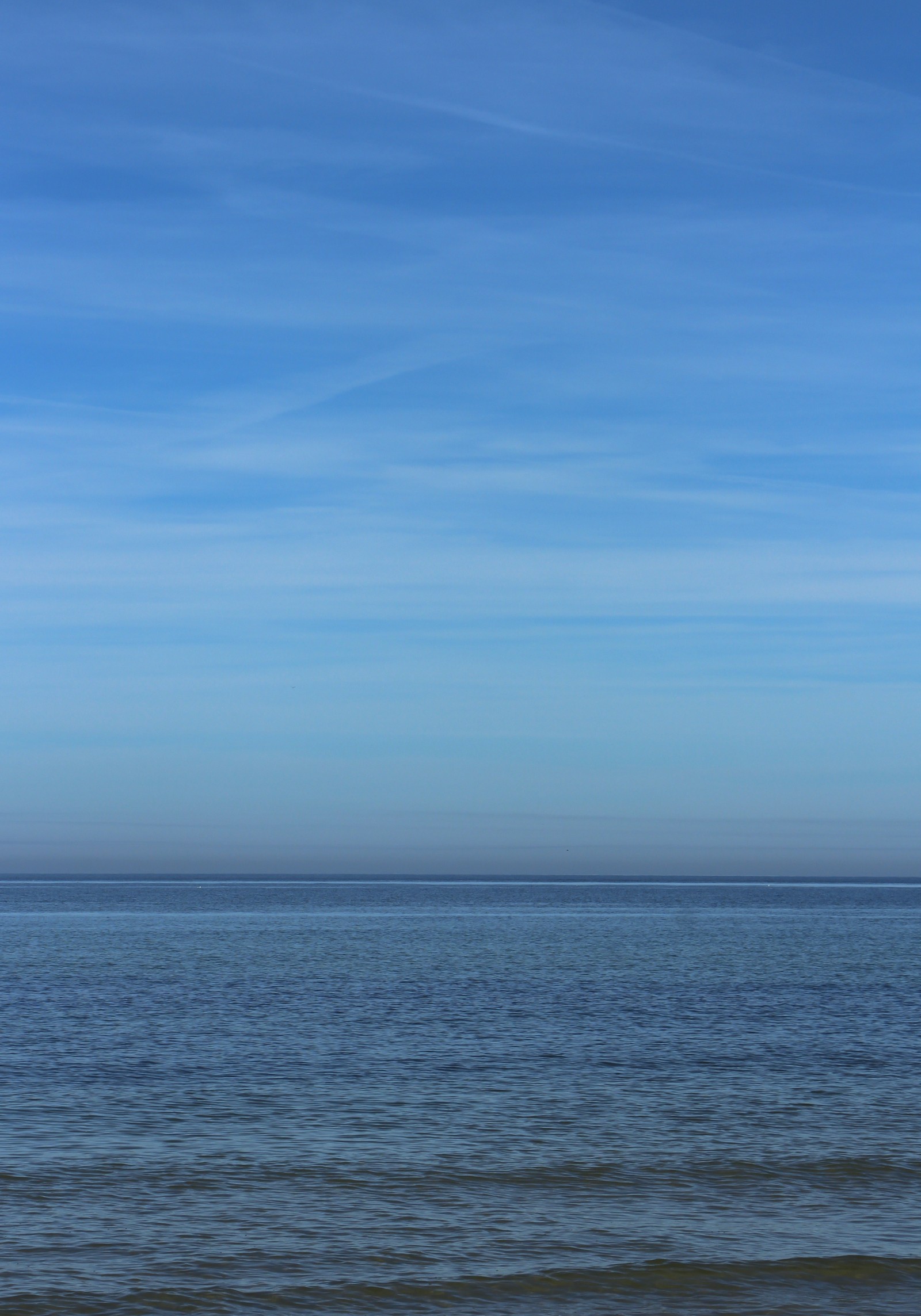 Il y a un petit bateau sur l'eau par une journée ensoleillée (mer, horizon, plan deau, bleu, océan)