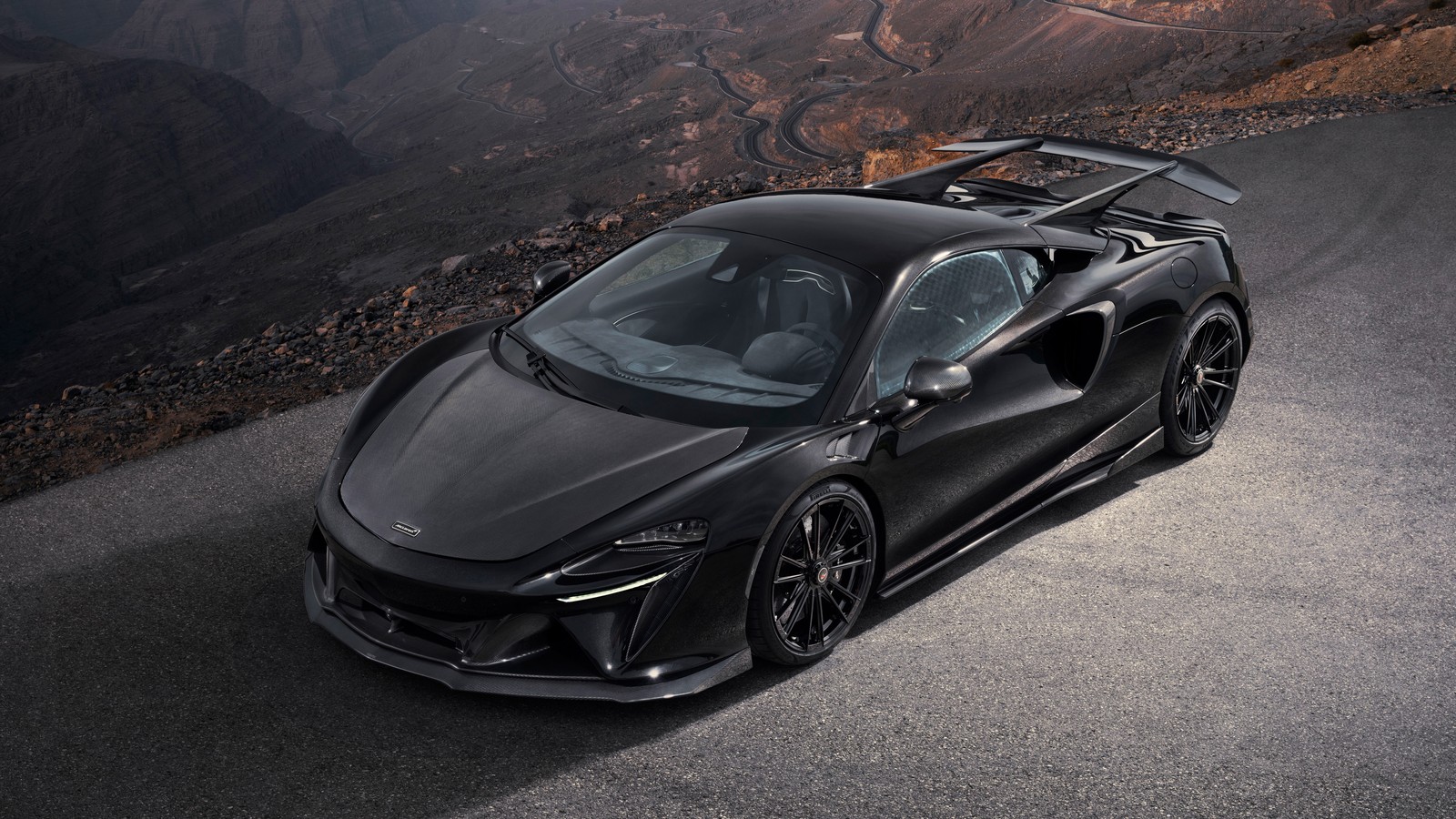 Ein schwarzes sportauto fährt auf einer straße mit bergen im hintergrund (novitec, mclaren artura, 2024, 5k, 8k)