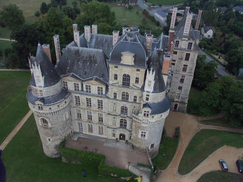 Une vue aérienne d'un château avec une tour et un chemin (château, bien immobilier, bâtiment, architecture médiévale, ferme)