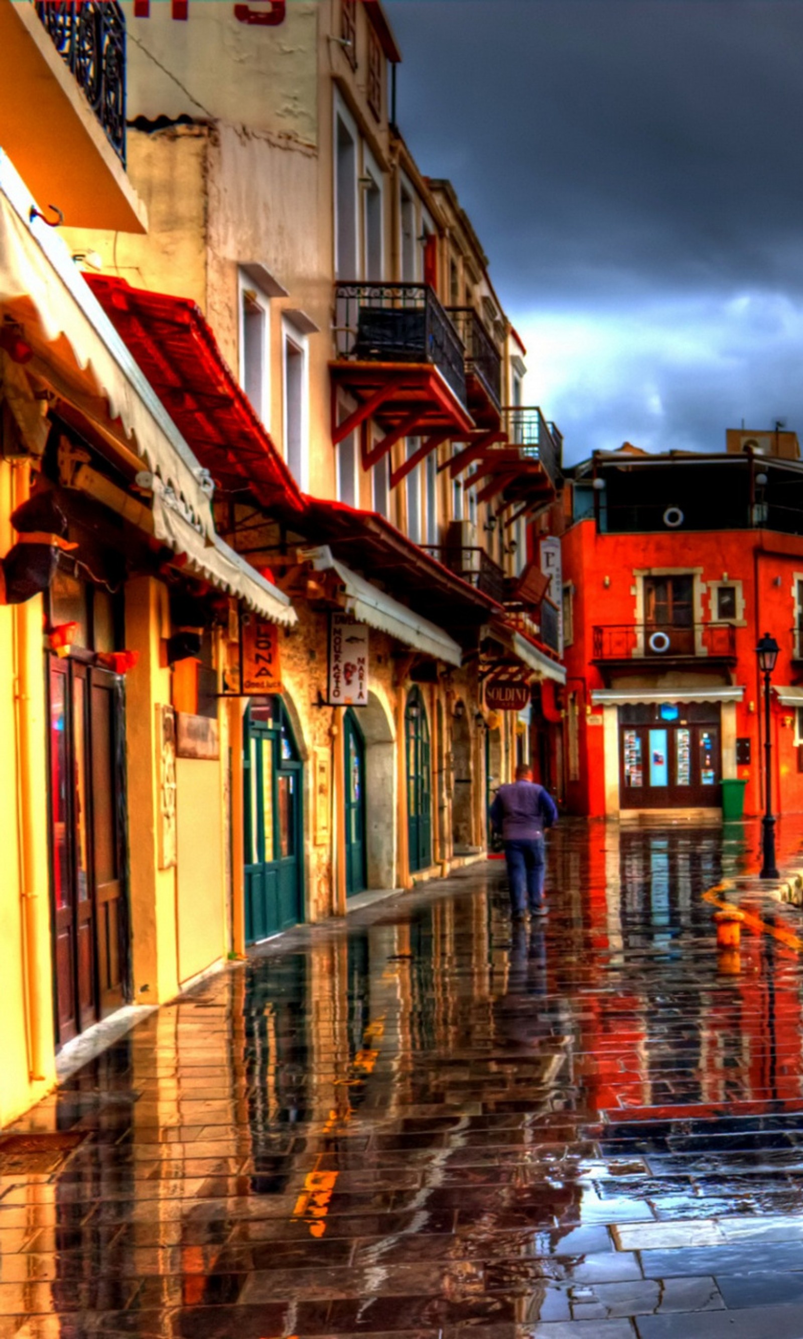 Há uma pessoa andando em uma rua molhada com um guarda-chuva (colorido, rua, viagem)