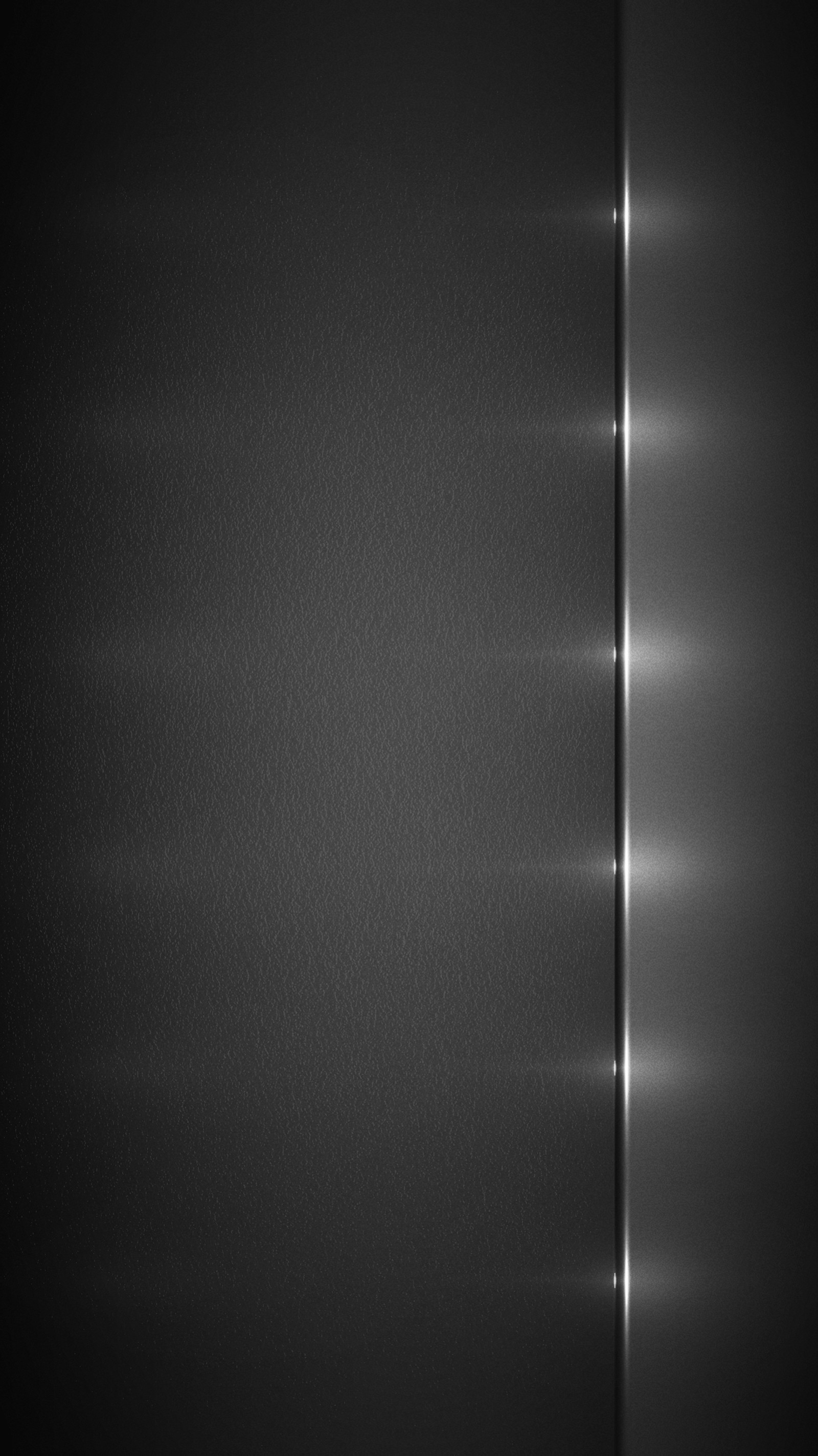 A close up of a black wall with a light shining down (silver, wallpaper)